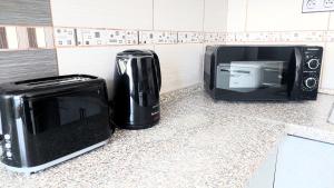 a microwave and a toaster on a kitchen counter at Metro Budějovická apartment in Prague +7 photos