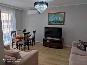 a living room with a couch and a table and a television at Himara City-Center Apartment in Himare +11 photos