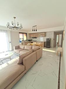 a large living room with a couch and a kitchen at Favorite Staycation by Janice - Modern Comfort Near Airport in Nairobi