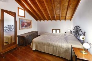 a bedroom with two beds and a wooden ceiling at Blue Cottage in Apsiou