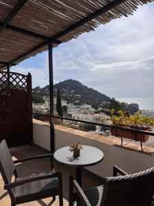 a table and chairs on a balcony with a view of the ocean at Casa Costanza in Capri +26 photos