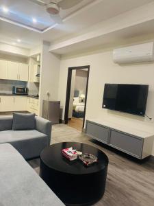 a living room with a couch and a tv and a table at Seven Star Heights in Rawalpindi