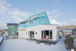 a house with a blue roof on top of a driveway at umiakari in Naruto