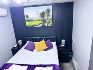 a bedroom with a bed with purple and yellow pillows at Verve Hotel in Bedford