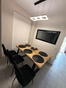 a dining room with a table with chairs and a tv at Thomi's house. in Yerakiní