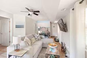 a living room with a white couch and a ceiling fan at Sandy Pines Perch - Your Indian River Dock Life Base Camp in Sebastian