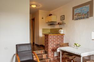 a living room with a table and a brick fireplace at Štanjelski Razgledi AR in Štanjel