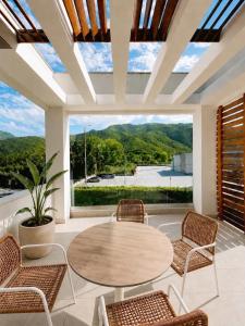 a patio with a table and chairs and a large window at Aelia Living in Stavros