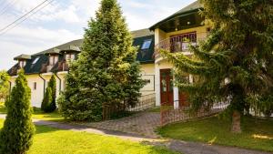a house with a tree in front of it at Éden Panzio in Bük