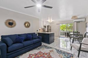 a living room with a blue couch and a kitchen at Newly Renovated Condo in Christiansted