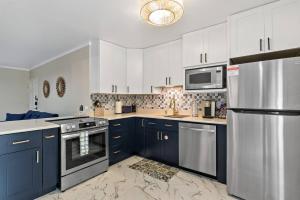 a kitchen with blue cabinets and a stainless steel refrigerator at Newly Renovated Condo in Christiansted