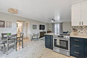 a kitchen and dining room with blue cabinets and a table at Newly Renovated Condo in Christiansted +2 photos