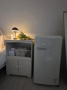 a small refrigerator next to a bed with a lamp at Dear, U in Gyeongju