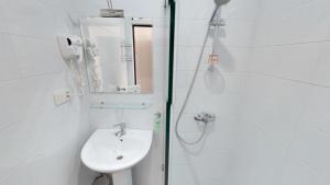 a white bathroom with a shower and a sink at Ossanna Hotel in Yerevan +28 photos