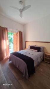 a bedroom with a large bed and a window at Pousada Guarujá, suítes Praia do tombo in Guarujá