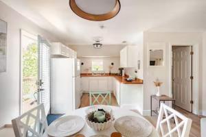 a kitchen with a table and a white refrigerator at Sandy Pines Perch - Your Indian River Dock Life Base Camp in Sebastian