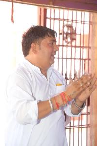 a man is standing in front of a gate at Hotel Tara ji Bliss in Haridwār