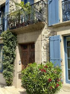 a building with a wooden door and some plants at L'oiseau Bleu suite MERLE BLEU in Roubia
