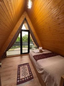 a attic room with a bed and a window at NerNeri Cottage Martvili in Martvili