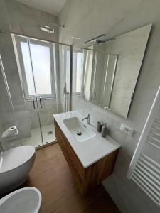a bathroom with a sink and a toilet and a shower at Casa Tania in Massa +7 photos