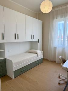 a bedroom with a bed with white cabinets and a window at Casa Tania in Massa