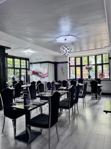 a dining room with tables and chairs and windows at Verve Hotel in Bedford