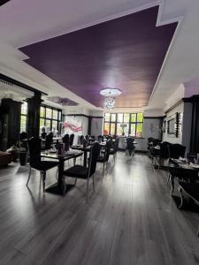 a dining room with tables and chairs and windows at Verve Hotel in Bedford