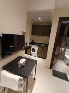 a small kitchen with a table and a stove at KAYAN ALAMAL HOTEL dubai in Dubai