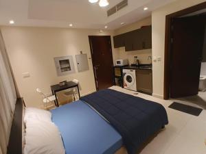 a bedroom with a blue bed and a kitchen at KAYAN ALAMAL HOTEL dubai in Dubai