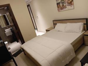 a bedroom with a large bed with white sheets at KAYAN ALAMAL HOTEL dubai in Dubai