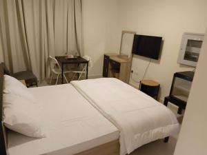 a bedroom with a bed and a table and a television at KAYAN ALAMAL HOTEL dubai in Dubai