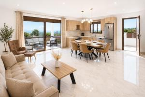 a living room and kitchen with a table and chairs at Luxury Villa John in Panormos Rethymno