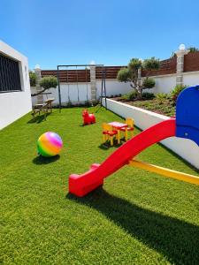 a playground with a slide and a ball on the grass at Luxury Villa John in Panormos Rethymno
