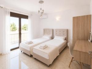 a white bedroom with two beds and a desk at Luxury Villa John in Panormos Rethymno +23 photos
