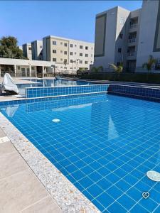 a swimming pool with blue tiles in front of buildings at Lugar tranquilo in Biguaçu