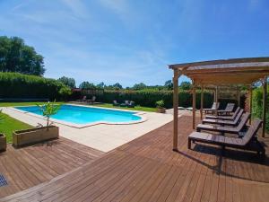 a deck with lounge chairs and a swimming pool at La Vieille Fromagerie in Brux