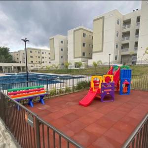 a playground with colorful play equipment next to a pool at Lugar tranquilo in Biguaçu