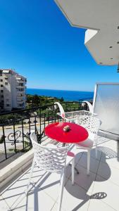 a table and chairs on a balcony with the ocean at ARILEO ROOMs in Himare