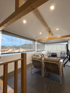 ein Wohnzimmer mit Sofa und großen Fenstern in der Unterkunft Casa do Parque Nature & Heritage Hotel in Castelo de Vide