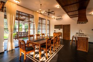 a dining room with a wooden table and chairs at K Manor in Vāzhākulam +39 photos