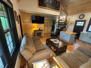 a living room with two couches and a fireplace at The Old Orchard Cottage in LaFayette