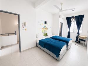 a bedroom with two beds and a desk in it at Singstay Guesthouse in Mersing