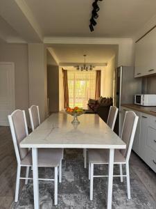 a white dining room table and chairs in a kitchen at Коттедж в Азиа Палас in Chon-Sary-Oy
