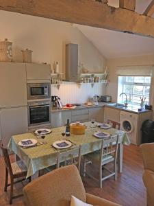 uma cozinha com uma mesa e cadeiras numa cozinha em Brooksides Byre Durham Country Cottage em Durham