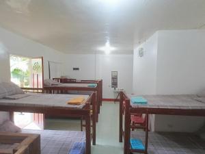a room with several tables and beds in it at Mamita Seaside Resort in Guinisiliban +30 photos
