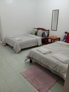 a room with two beds and a table and a mirror at Mamita Seaside Resort in Guinisiliban