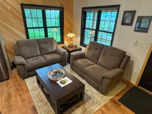 a living room with two couches and a coffee table at The Old Orchard Cottage in LaFayette