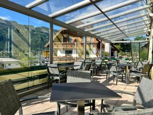 a restaurant with tables and chairs and windows at Pension Neuhof in Ossiach