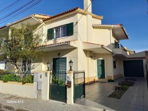 a house with a green gate in front of it at Marcio's Home in Fernao Ferro