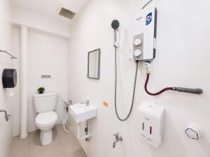 a white bathroom with a toilet and a sink at Singstay Guesthouse in Mersing +30 photos